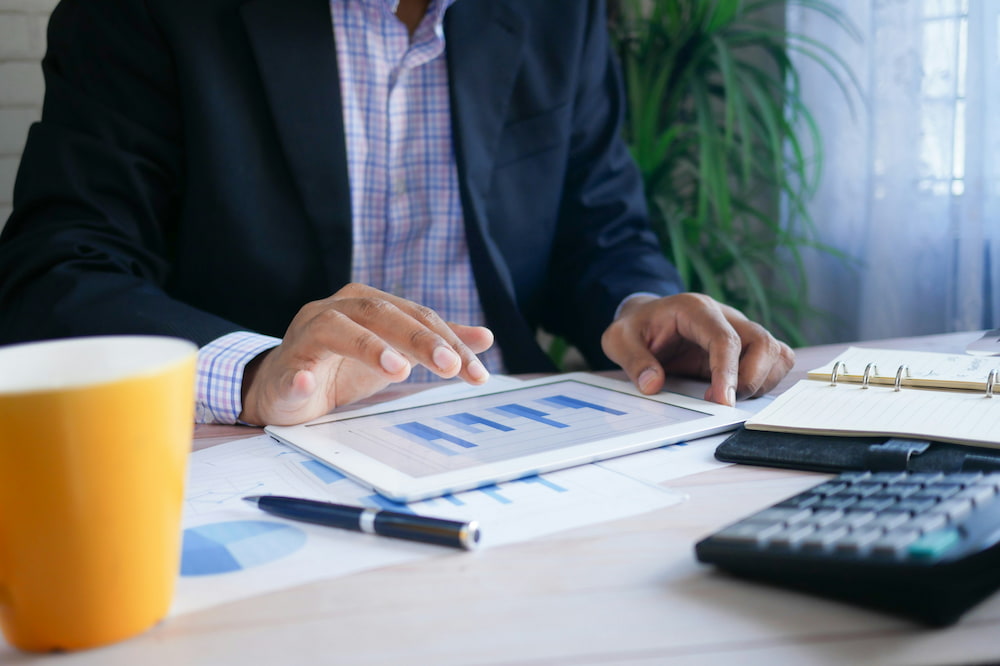 Man sat at desk looking at iPad at his SaaS accounting software